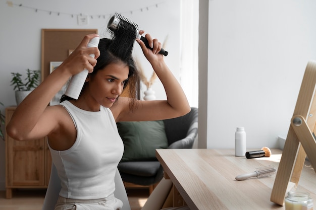 Femme à coup moyen utilisant du shampoing sec à la maison