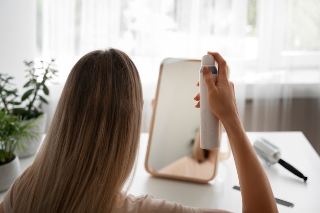 Femme à coup moyen utilisant du shampoing sec à la maison