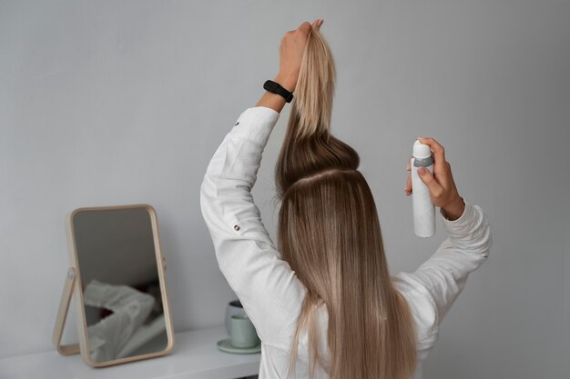 Femme à coup moyen utilisant du shampoing sec à la maison