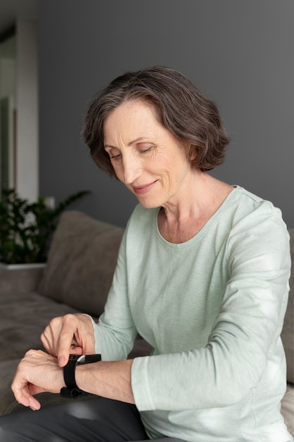 Photo gratuite femme de coup moyen vérifiant la smartwatch