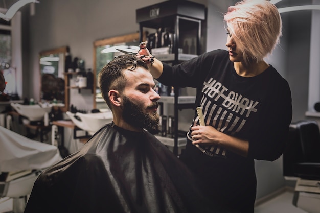 Femme coupe les cheveux de l&#39;homme au salon