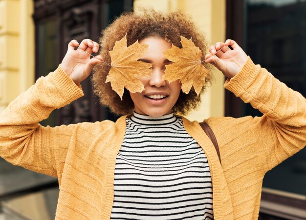 Femme couvrant ses yeux avec des feuilles sèches