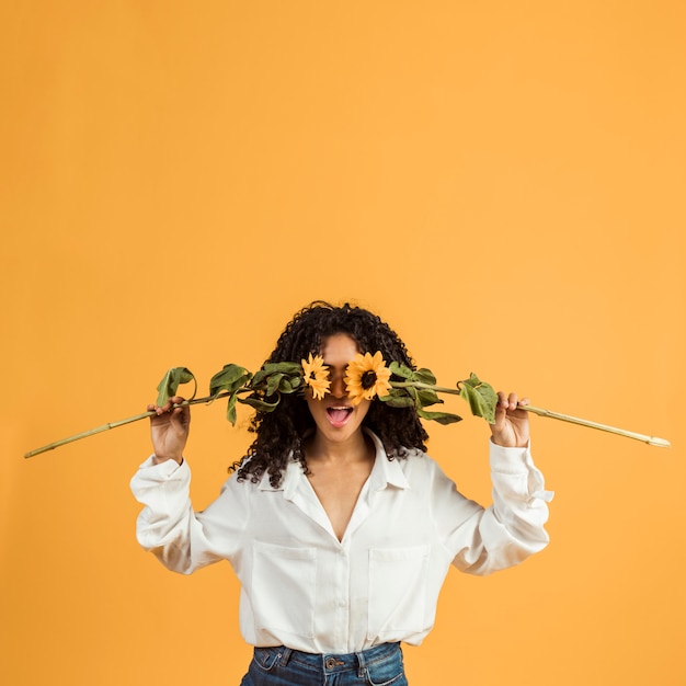 Photo gratuite femme couvrant le visage avec des fleurs