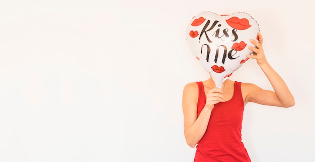 Femme, couvrir visage, à, grand coeur, ballon