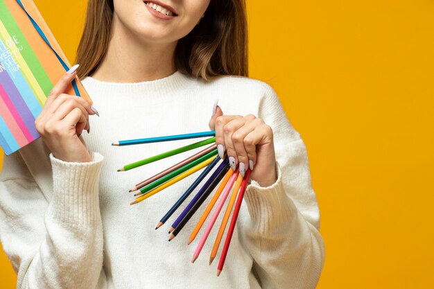 Femme avec des crayons colorés et bloc-notes colorés