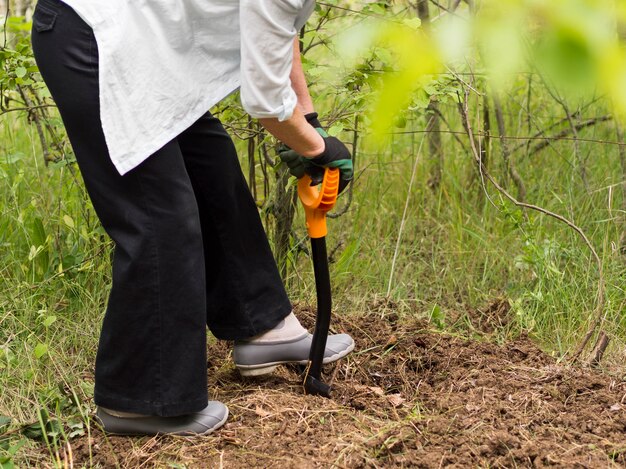 Femme creusant dans son jardin