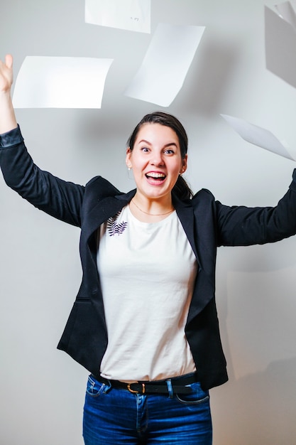 Photo gratuite femme criante et souriante jetant des papiers