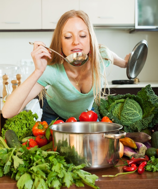 Femme cuisinant à la louche de légumes