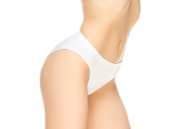 Femme en culotte blanche posant sur blanc