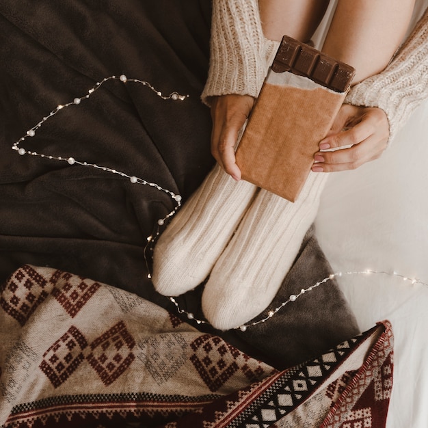 Photo gratuite femme de culture avec du chocolat sur le lit