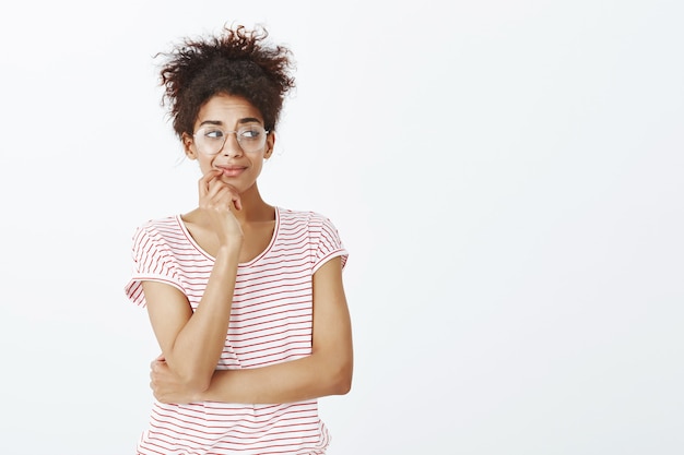 Photo gratuite femme curieuse avec une coiffure afro qui pose en studio