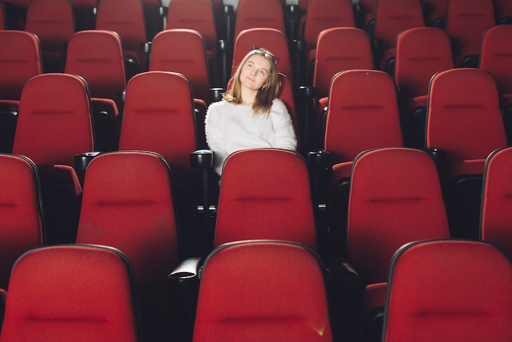 Photo gratuit femme dans l'auditorium de cinéma vide