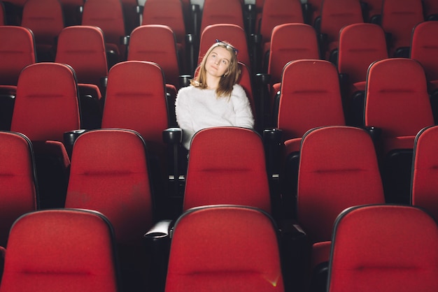 Femme dans l&#39;auditorium de cinéma vide