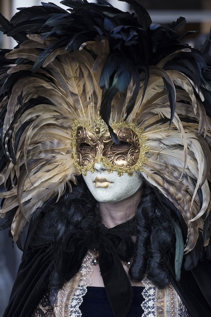 Femme dans une belle robe et masque traditionnel de Venise pendant le carnaval de renommée mondiale