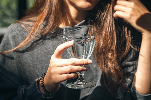 Photo gratuite une femme dans un café tient un verre d'eau dans sa main