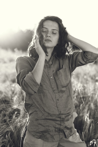 Femme dans un champ d'été. Brunette dans une chemise verte.