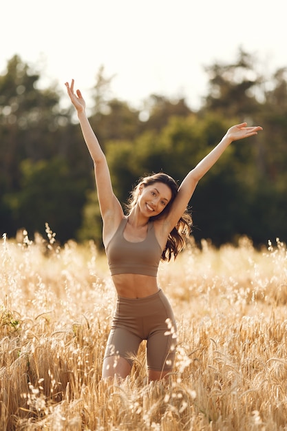 Photo gratuite femme dans un champ d'été. brunette dans un costume de taches.