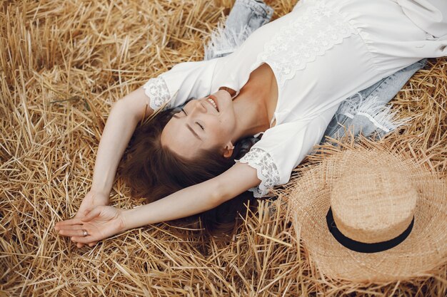 Femme dans un champ d'été. Dame en robe blanche.