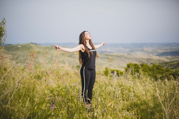 Photo gratuite femme dans l'herbe à mains jointes