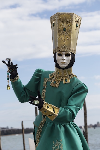 Femme dans un masque traditionnel de Venise pendant le carnaval de renommée mondiale