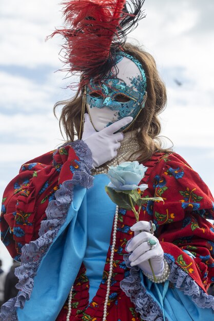 Femme dans un masque traditionnel de Venise pendant le carnaval de renommée mondiale