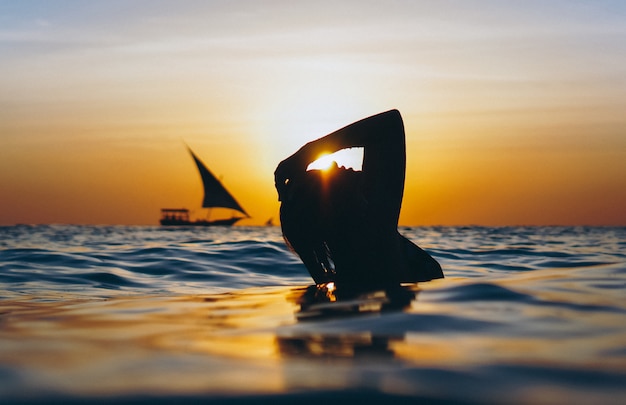 Femme dans l'océan au coucher du soleil