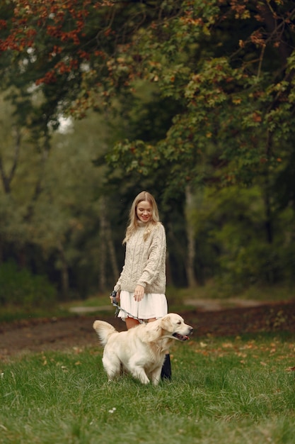 Femme dans un pull marron. Dame avec un labrador. Des amis s'amusent dehors.