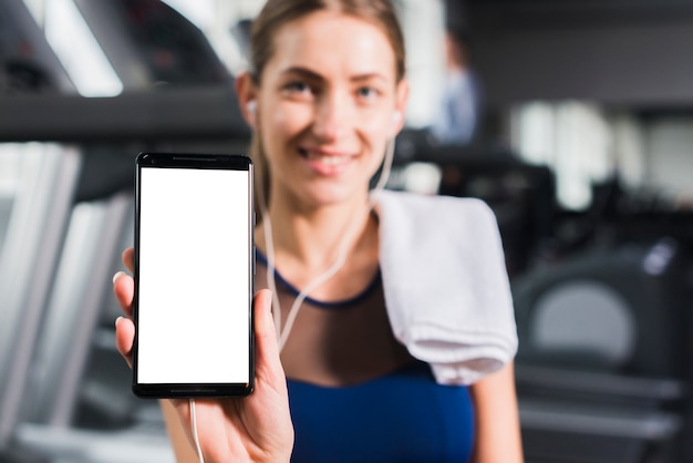 Femme dans une salle de sport avec un modèle de smartphone