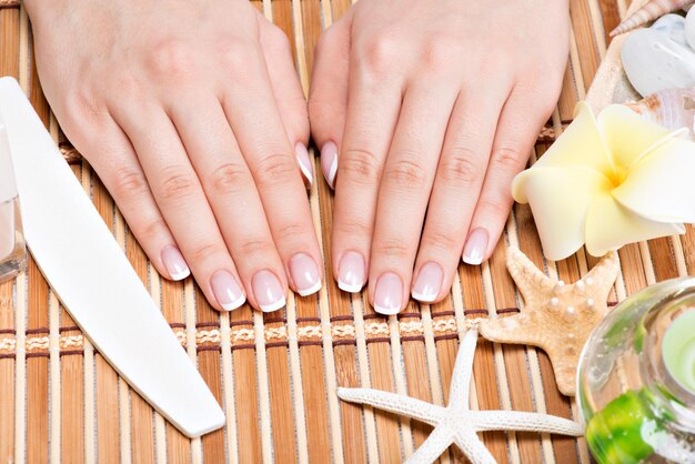 Femme dans un salon de manucure recevant une manucure par une esthéticienne. Concept de traitement de beauté.