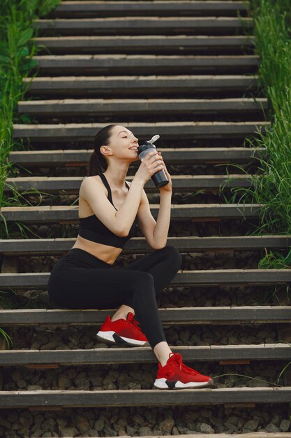 Femme dans un spoerswear noir debout sur un escalier