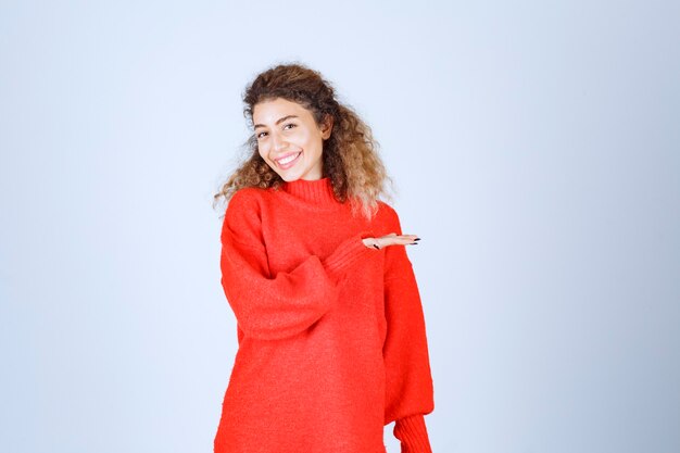 femme dans un sweat-shirt rouge pointant sur différents côtés.