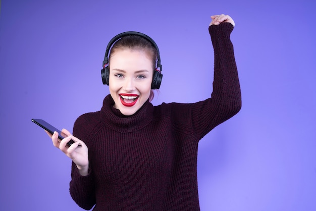 Femme danse, à, écouteurs, sur, tête, et, téléphone portable, dans, main