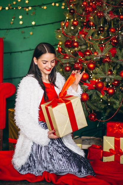 Femme, déballage, noël, cadeau, par, noël, arbre