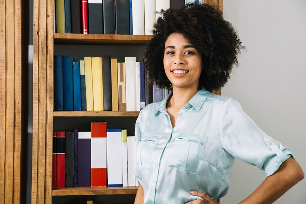 Femme, debout, bibliothèque, bureau