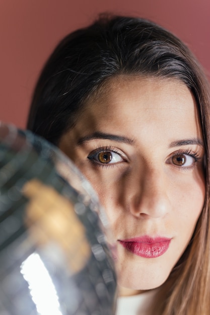 Photo gratuite femme debout avec une boule disco