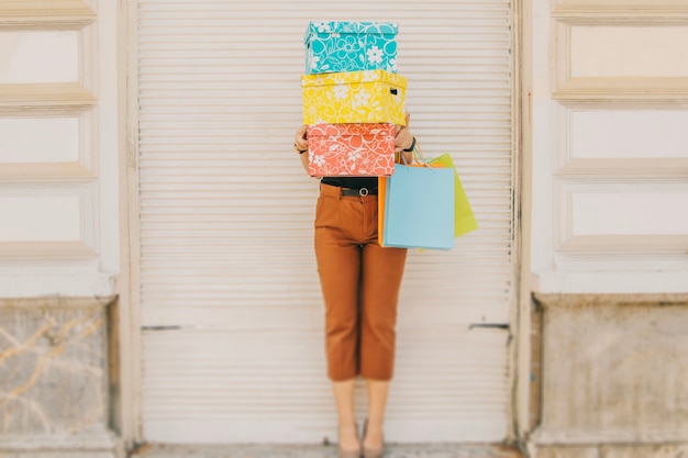 Photo gratuite femme debout derrière des boîtes avec des achats