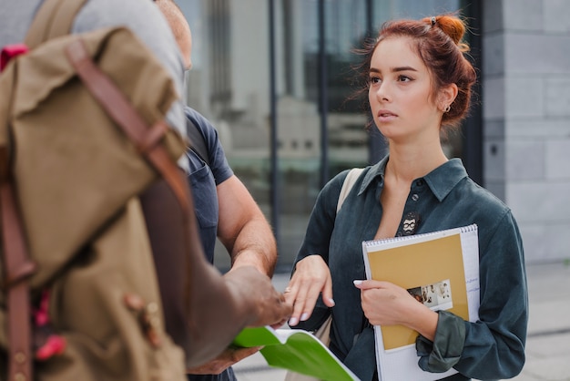 Photo gratuite femme debout avec des étudiants masculins