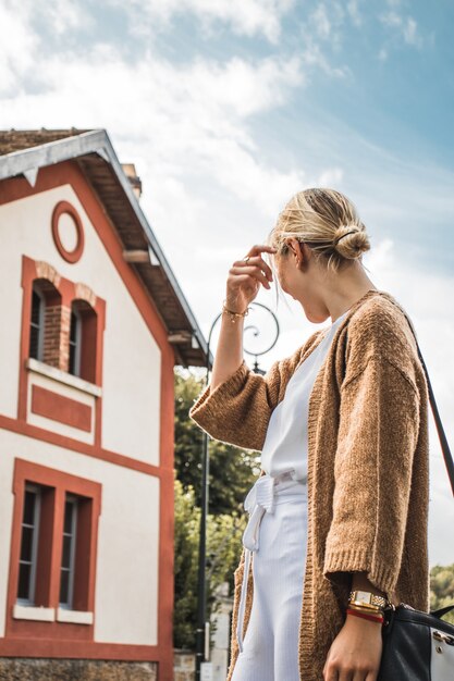 Femme debout à l'extérieur de la maison pendant la journée ensoleillée