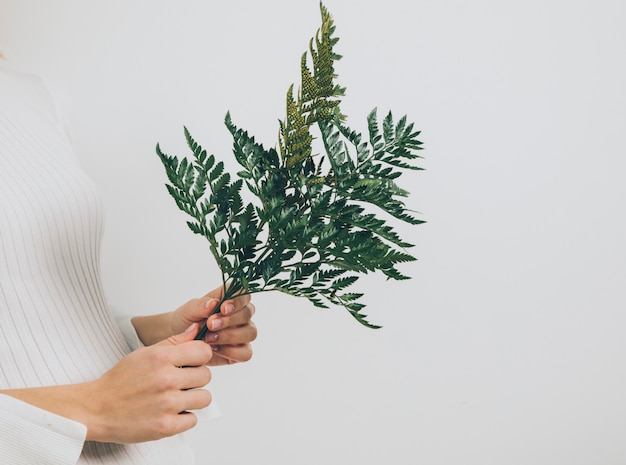 Femme debout avec des feuilles de fougère