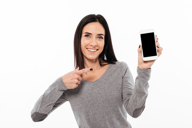 Femme debout isolé montrant l'affichage du téléphone mobile.