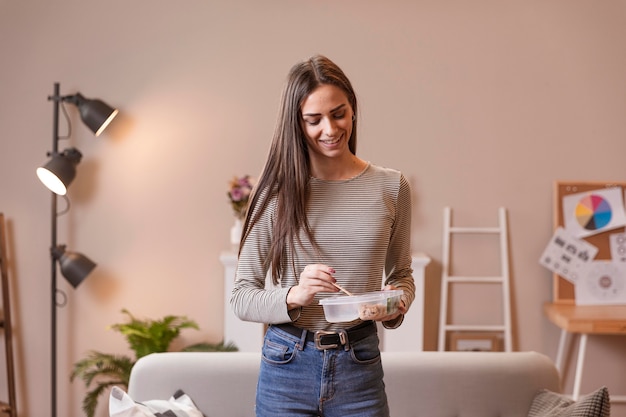 Femme, debout, manger, déjeuner, pause