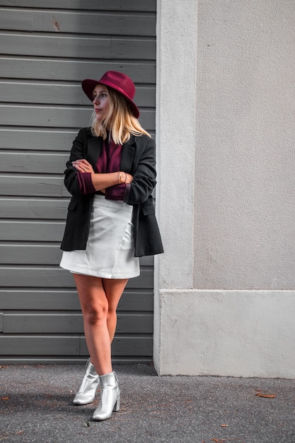 Femme debout traversant ses jambes et ses bras tout en la regardant à droite