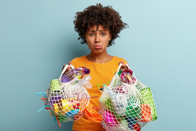 Photo gratuite femme avec des déchets plastiques dans un sac en filet