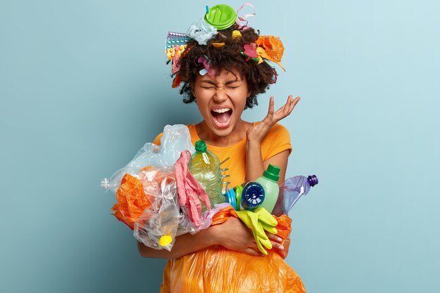 Femme avec des déchets plastiques dans un sac en filet