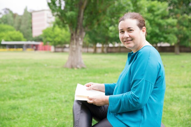 Femme décontractée heureuse avec livre appréciant le week-end