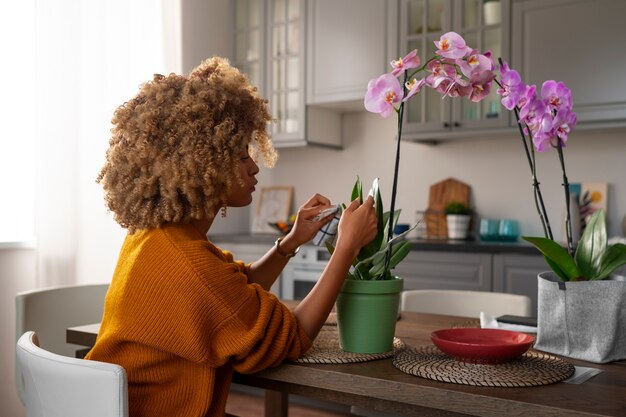 Femme décorant sa maison avec des orchidées