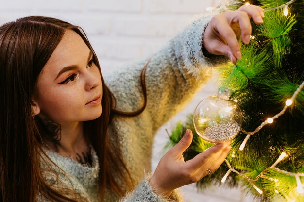 Femme décorant le sapin de Noël