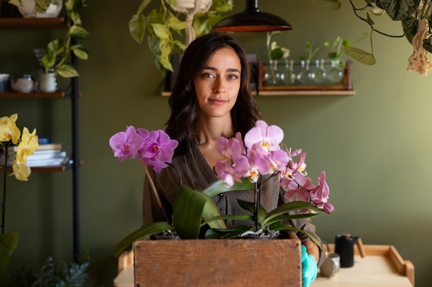 Photo gratuite une femme décore sa maison d'orchidées.