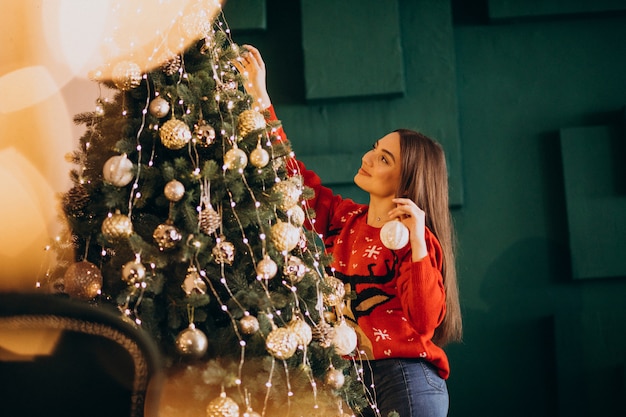 Femme décorer un sapin de Noël à Noël