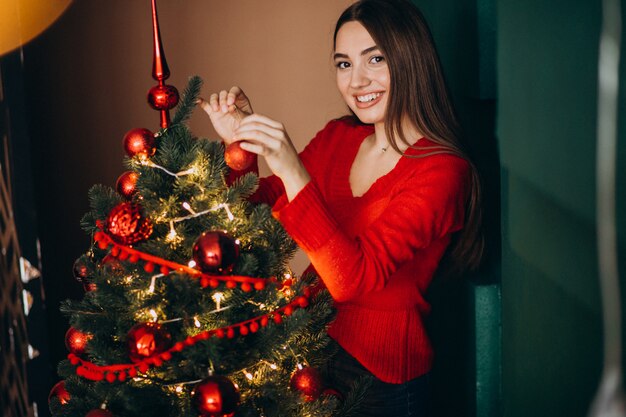 Femme décorer un sapin de Noël à Noël